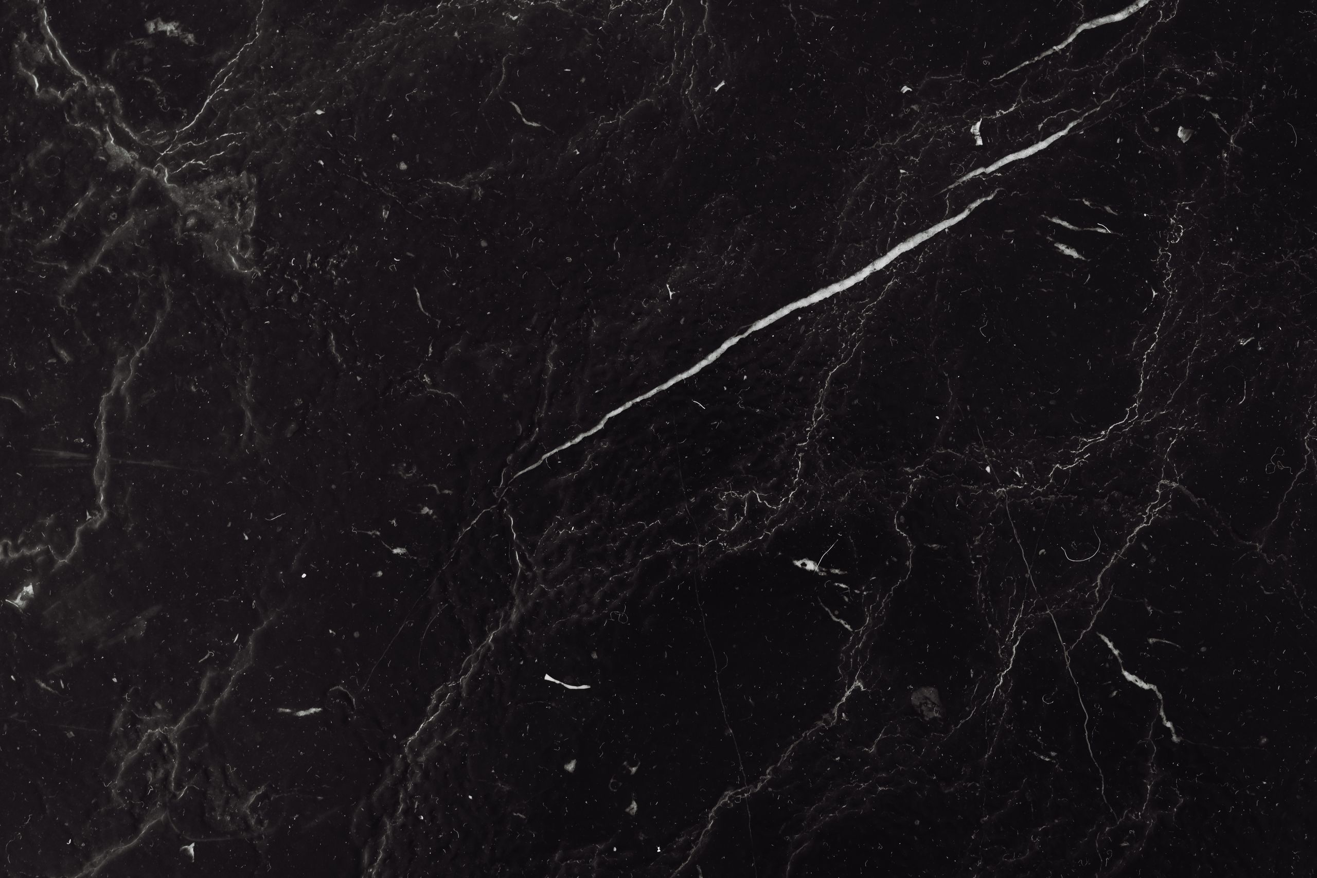 Sophisticated black marble texture with natural veining ideal for backgrounds and design projects.